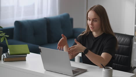 young-woman-is-communicating-by-online-chat-in-laptop-distance-meeting-talking-and-gesticulating-looking-at-screen-remote-working-from-home